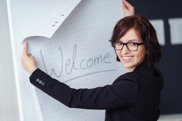 Frau mit Clipboard mit der Aufschrift Welcome